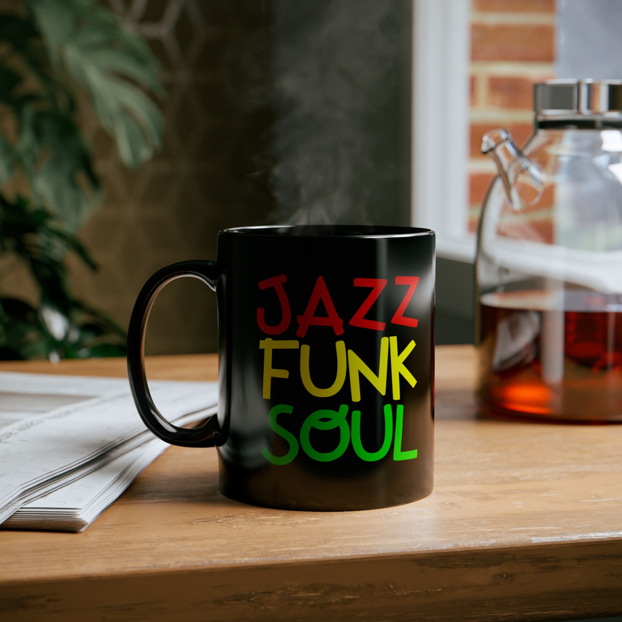 A black coffee mug with unusual funky font saying JAZZ, FUNK, SOUL, in red, yellow & green.